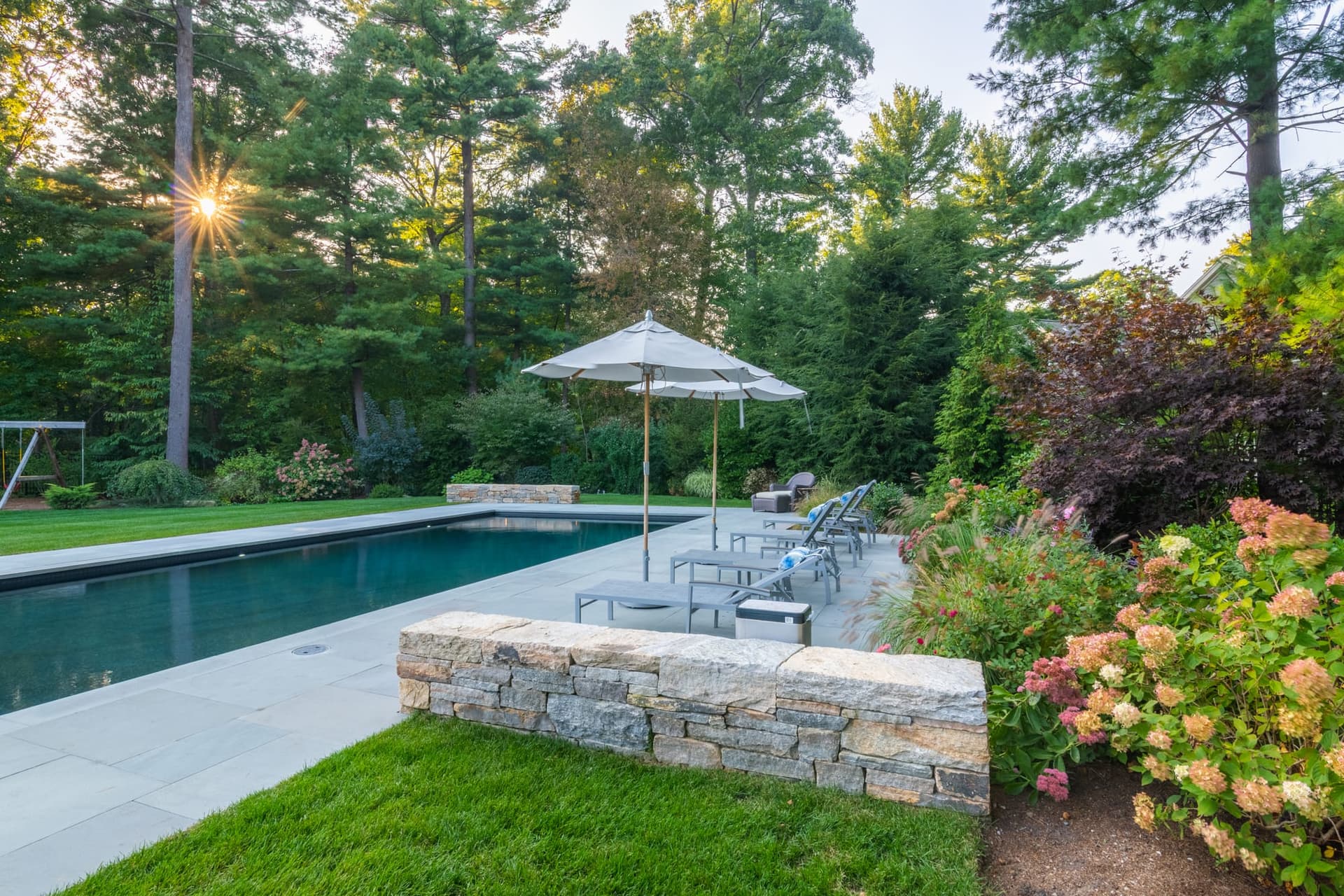 Cornell Road — pool terrace and stone wall at dusk in Wellesley, MA