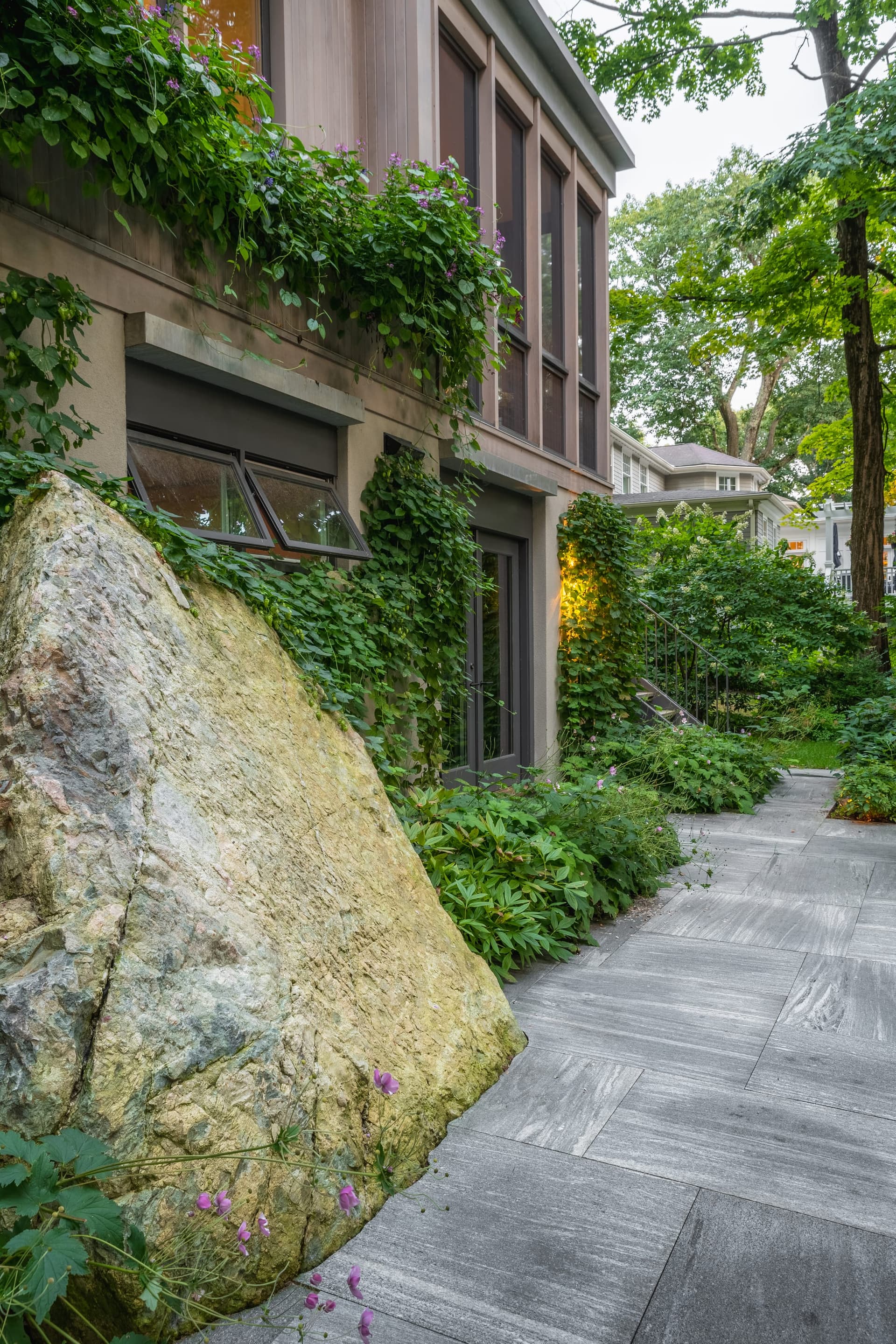 Abbott Road — glacial boulder set against the house and stone paving in Wellesley, MA