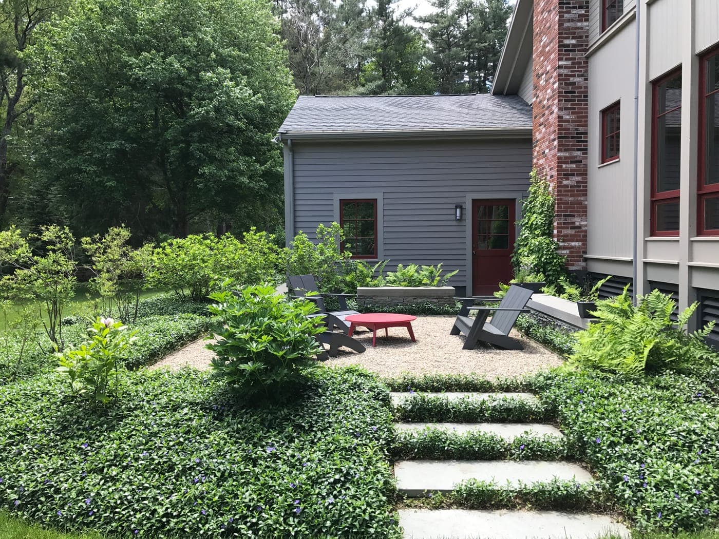 Natural stone patio bordered by fieldstone walls in Needham, MA